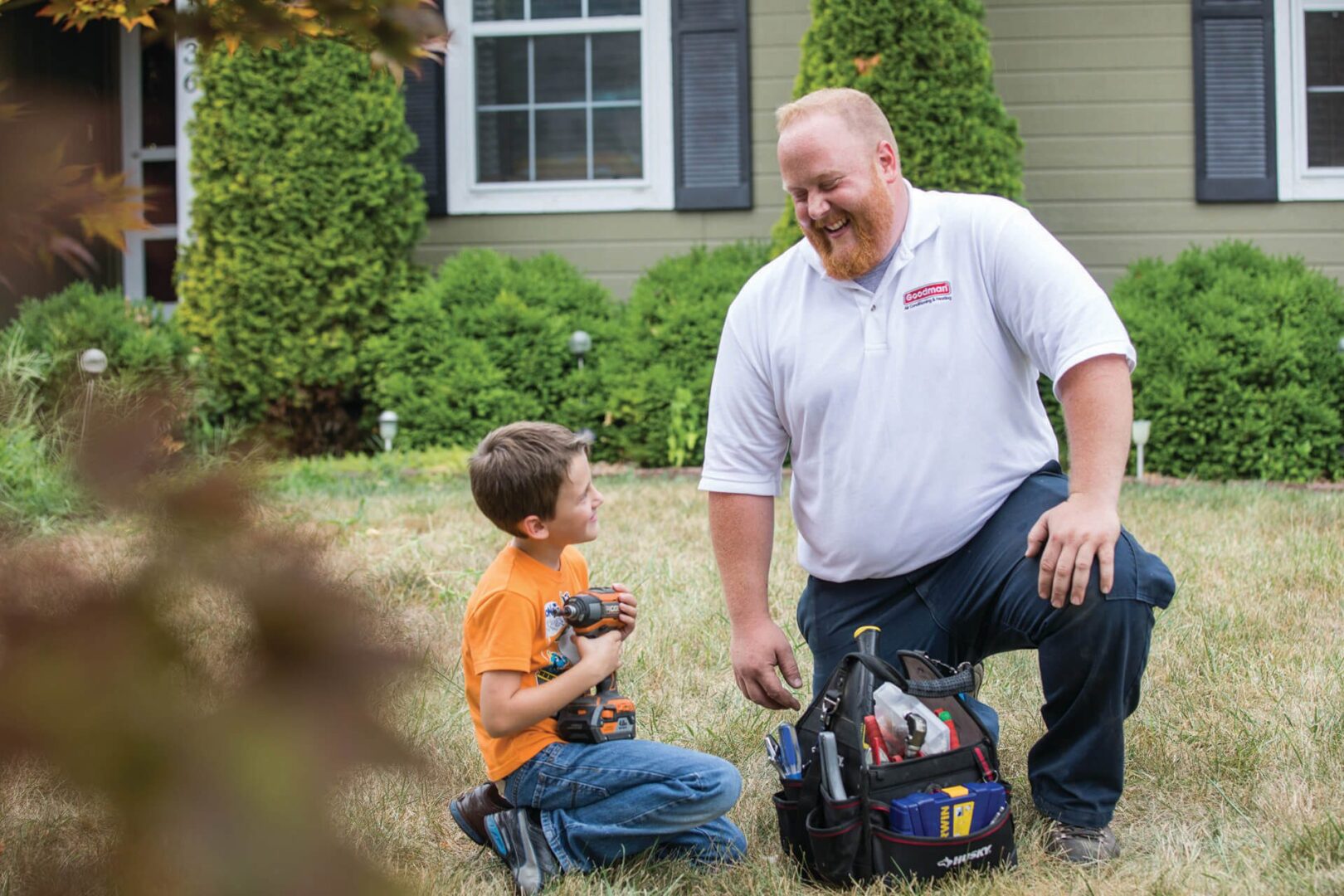 A man and boy in the grass with tools.