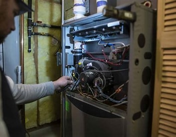 Technician inspecting an open furnace system.